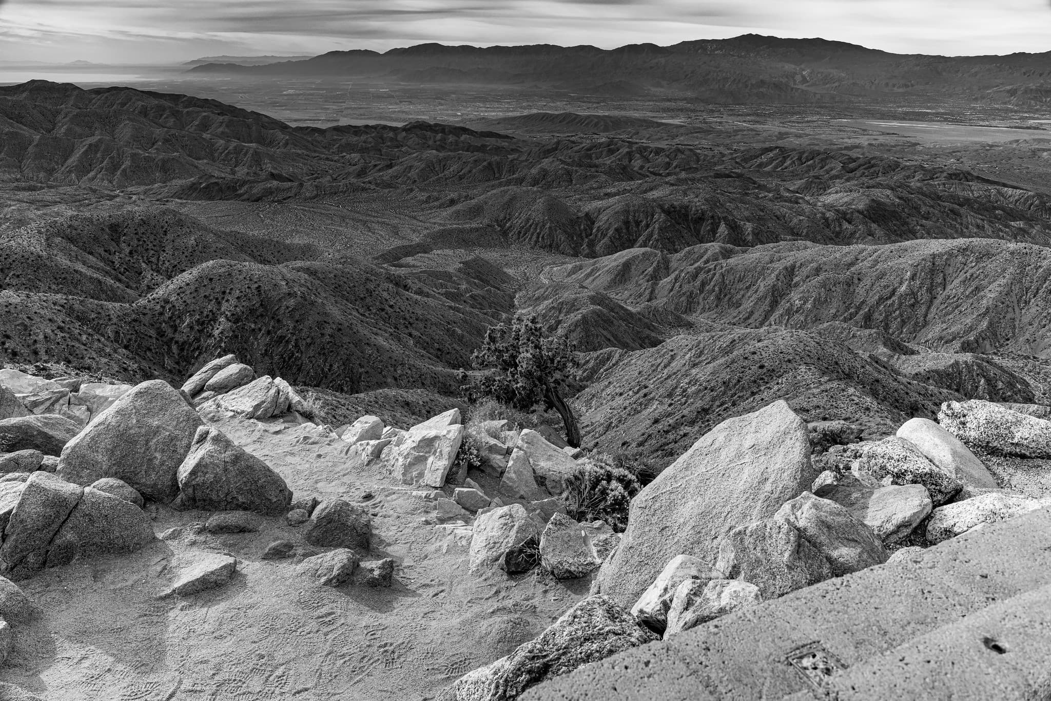 Black and white desert landscape with ridges and rocks.